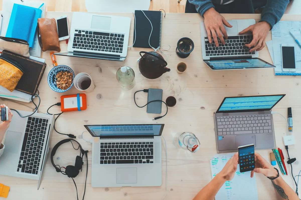 Personas analizando datos y código en múltiples pantallas